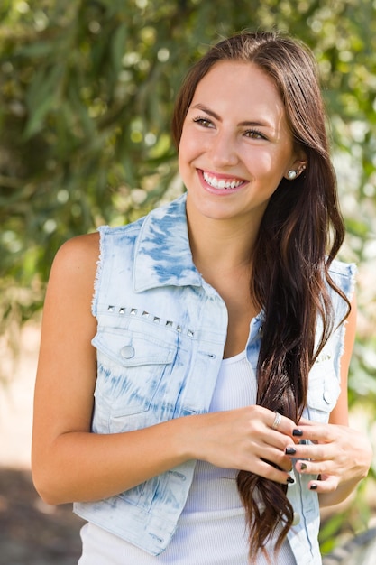 Photo portrait d'une fille de race mixte attrayante et souriante en plein air