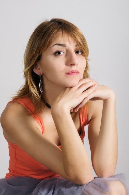 Portrait de fille rousse dans une chemise orange et une jupe bleue translucide