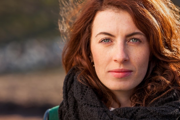 Portrait d'une fille rousse dans la rue Elle attend avec impatience et regarde avec confiance