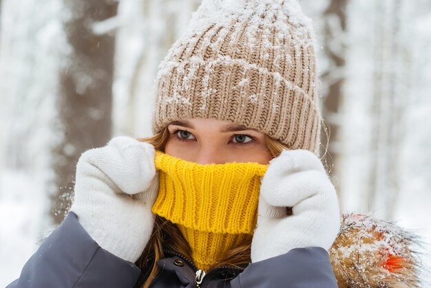 Portrait d'une fille se réchauffant avec son souffle cachant son nez dans le col d'un pull chaud