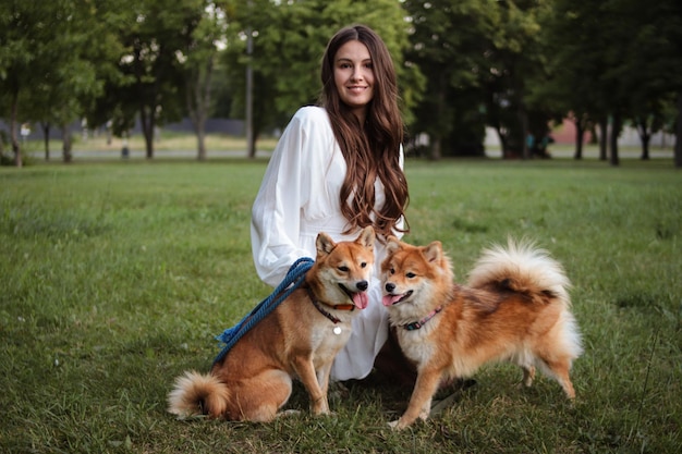 Portrait d'une fille avec ses chiens japonais Shiba Inu. Beaux chiens rouges moelleux. Photographie en extérieur