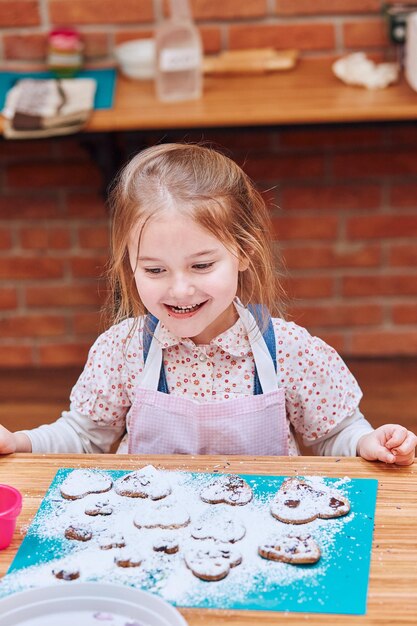 Photo portrait d'une fille souriante assise sur une table