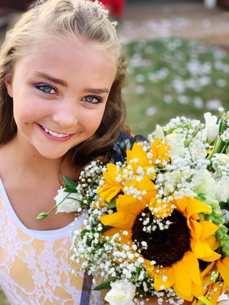 Photo portrait d'une fille souriante avec un bouquet