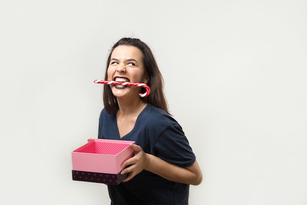 Portrait d'une fille souriante heureuse ouvrant une boîte-cadeau isolée sur fond blanc