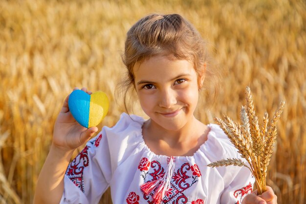 Portrait d'une fille souriante tenant une forme de cœur à la ferme