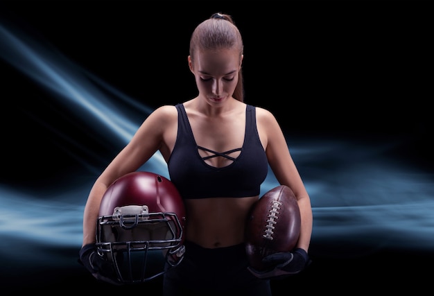 Portrait d'une fille sportive dans l'uniforme d'un joueur de l'équipe de football américain. Notion de sport. Contexte futuriste. Technique mixte
