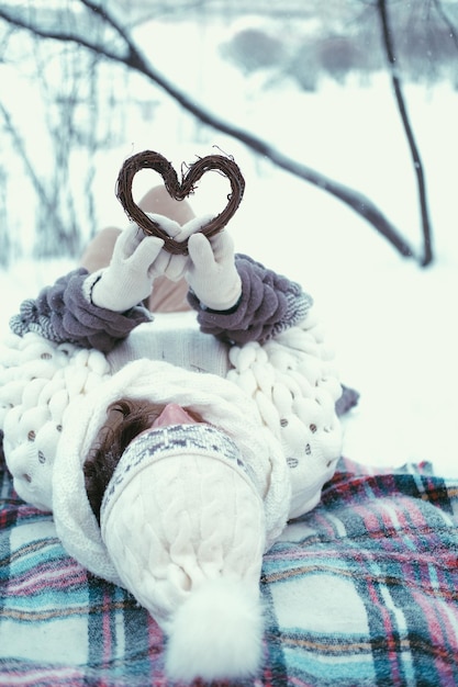 Portrait d'une fille tenant une décoration de Noël en bois faite à la main en forme de coeur