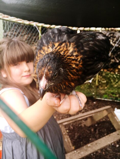 Photo portrait d'une fille tenant une poule