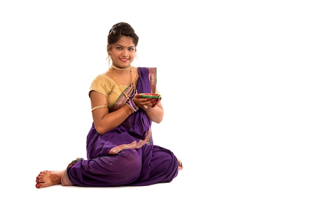 Portrait d'une fille traditionnelle indienne tenant diya
