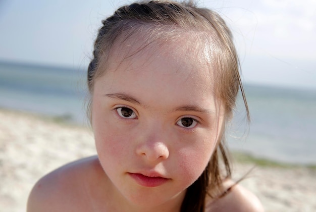 Portrait d'une fille trisomique souriante sur fond de mer