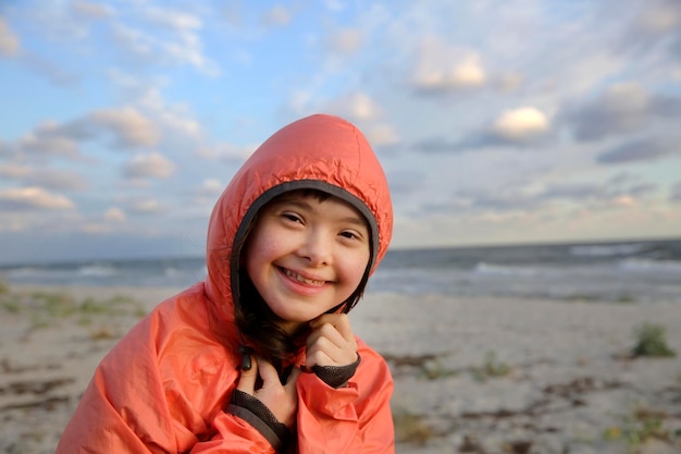 Portrait d'une fille trisomique souriante sur fond de mer