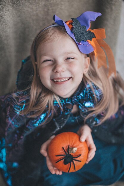 Portrait d'une fille en vêtements de carnaval pour Halloween avec une citrouille