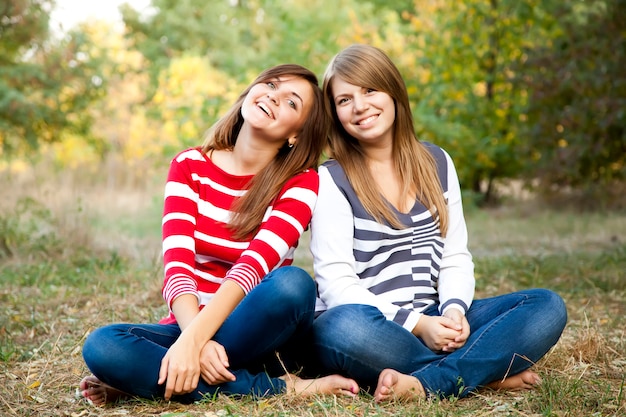 Portrait de filles rousse et brune en plein air.