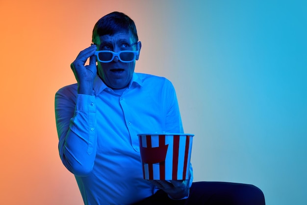 Portrait de film d'horreur d'un homme d'âge mûr mature posant dans des verres d et du pop-corn sur un bleu dégradé