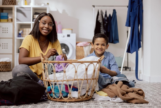 Portrait fils aide la mère avec les tâches ménagères les femmes trient les vêtements de pli de blanchisserie