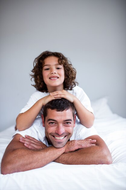 Portrait d'un fils couché sur le dos des pères