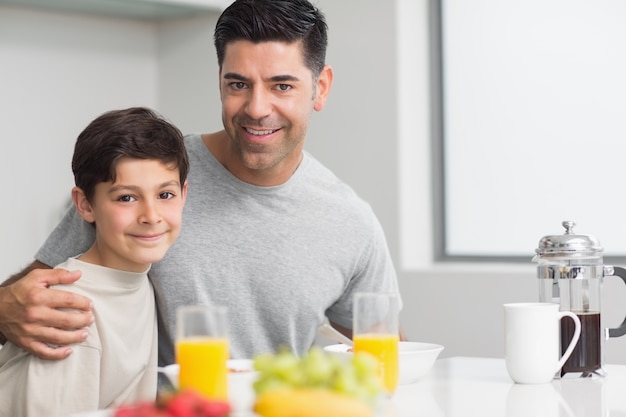 Portrait de fils heureux avec père prenant son petit déjeuner