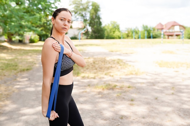 Portrait de fit et sportive jeune femme faisant des étirements en ville.