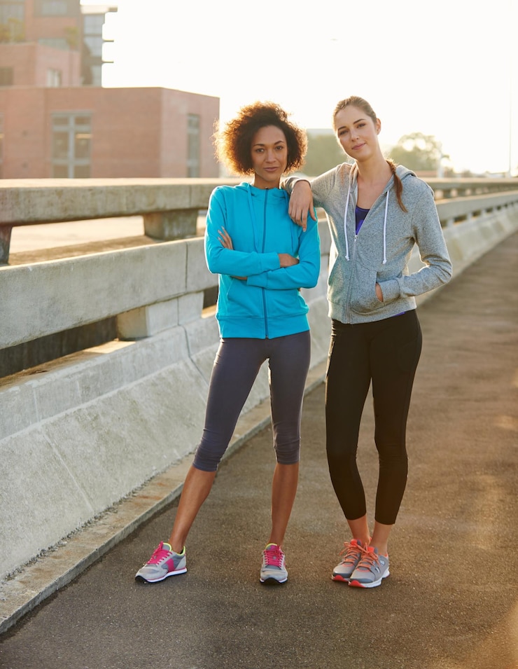Photo portrait de fitness et de femmes en confiance en ville pour s'entraîner ou faire de l'exercice en plein air ensemble jeune femme ou coureuse avec un sourire ou des bras croisés pour courir ou faire du cardio dans une ville urbaine