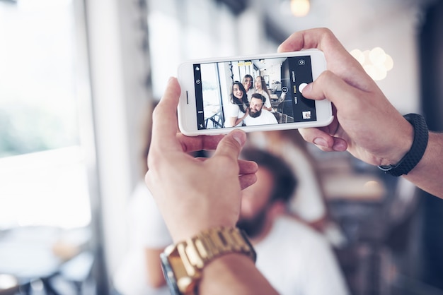 Portrait de flou de bonheur jeunes meilleurs amis avec les mains tenant le téléphone au premier plan