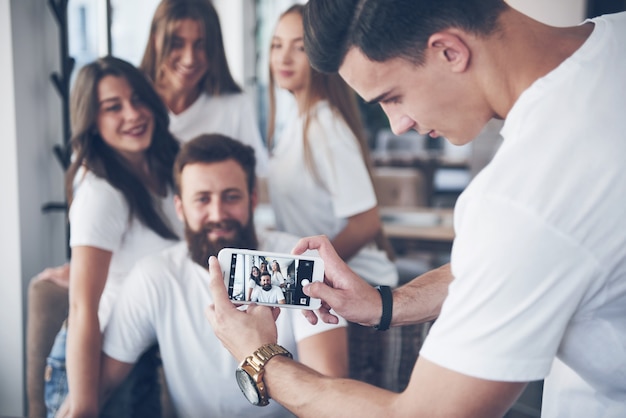 Portrait flou de jeunes meilleurs amis heureux avec les mains tenant le téléphone au premier plan.