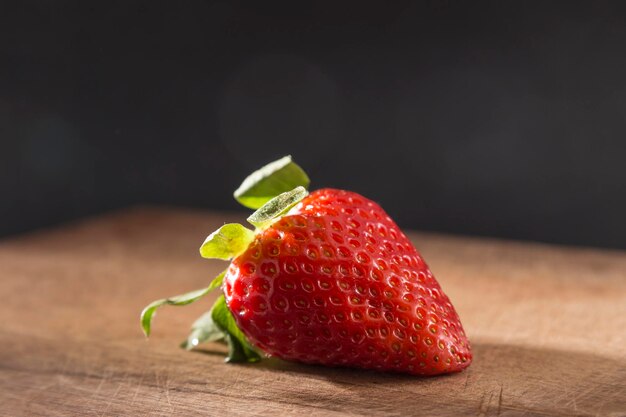 Portrait d'une fraise posée sur une planche de bois aliments frais et naturels