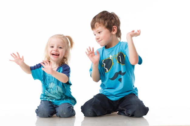 Portrait d'un frère et d'une soeur blonds bouclés aux yeux bleus riant joyeusement sur un fond blanc Children39s émotions bonheur joie amusement Beaux enfants mignons Amitié