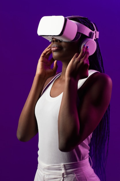 Portrait futuriste vertical d'une jeune femme afro-américaine portant un casque VR sur fond violet