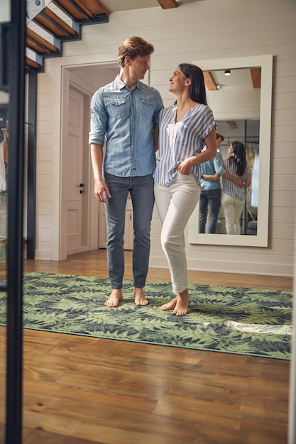 portrait gai beau couple debout dans le salon tout en se regardant