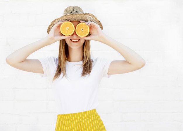 Portrait, de, a, gaie, jeune fille, tenue, deux, tranches, de, a, orange, elle, visage, sur, mur blanc