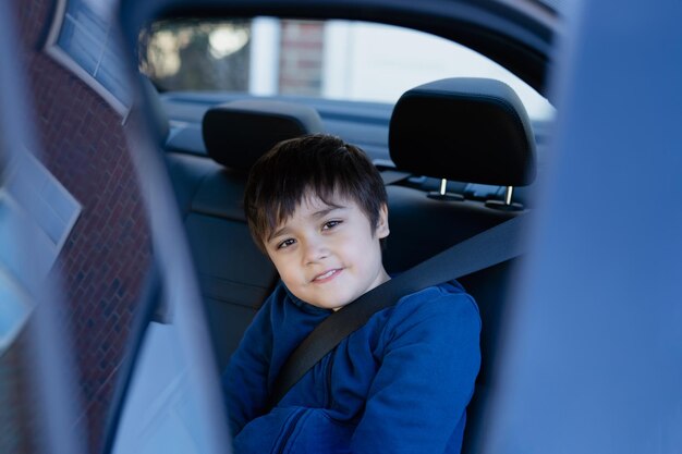 Portrait d'un garçon assis dans une voiture