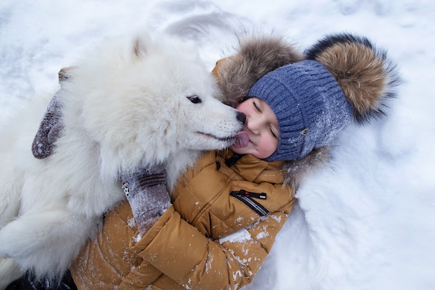 portrait d'un garçon avec un chien dans une forêt d'hiver