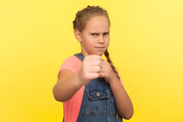 Photo portrait d'un garçon debout sur un fond jaune