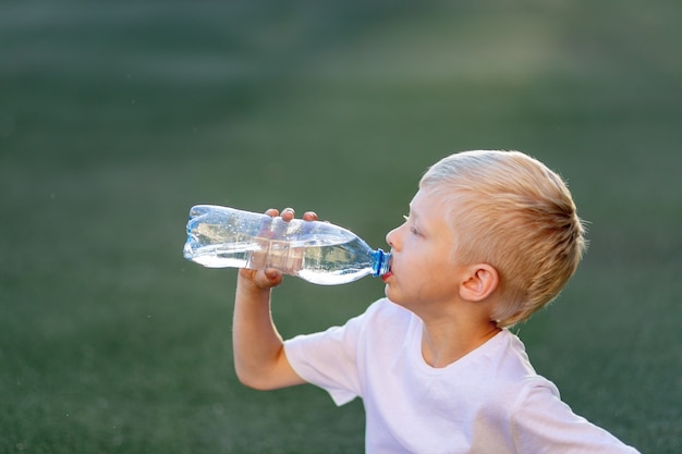 Portrait d'un garçon de l'eau potable dans le terrain de football