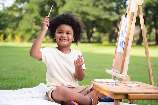 Photo portrait garçon enfant afro-américain peignant dans le parc