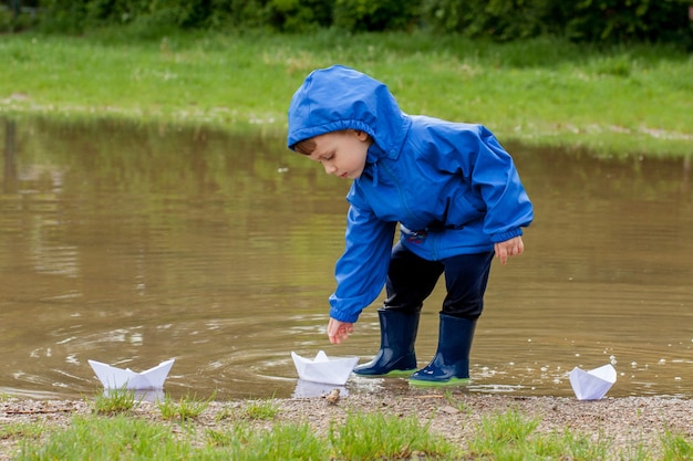 Portrait de garçon enfant mignon jouant avec un bateau à la main.