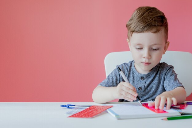 Portrait de garçon enfant mignon à la maison à faire ses devoirs.