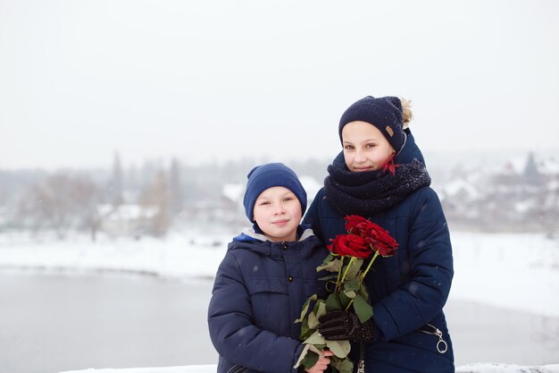 Portrait d'un garçon et d'une femme avec des roses rouges le jour de la Saint-Valentin