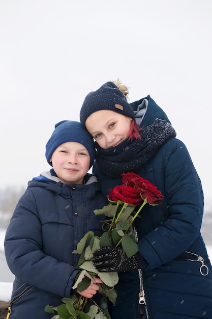 Portrait d'un garçon et d'une fille avec des roses rouges le jour de la Saint-Valentin