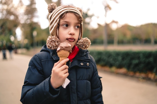 Photo portrait d'un garçon heureux debout sur une crème glacée