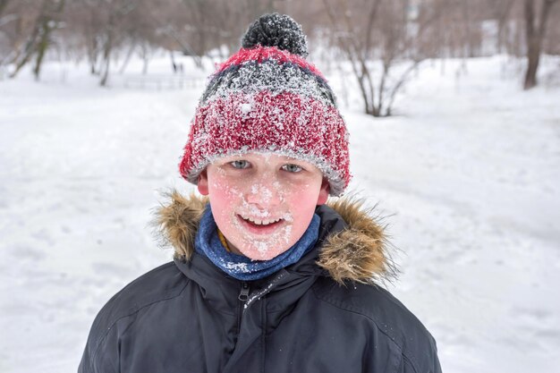 Le portrait d'un garçon en hiver Un gros plan Tout le visage dans la neige