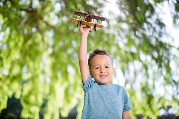 Portrait de garçon jouant avec un avion jouet dans le parc