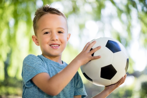 Portrait de garçon jouant avec un ballon de football dans le parc