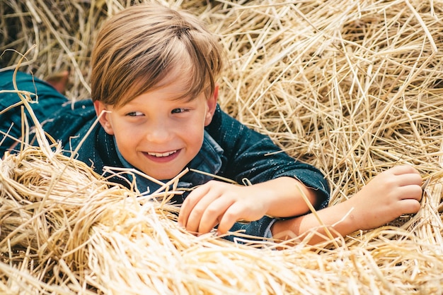 Portrait d'un garçon joyeux couché dans un foin rêve d'automne kid rêves sur l'automne nature rêve d'enfance c