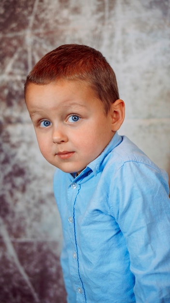 portrait d'un garçon mignon dans une chemise bleue