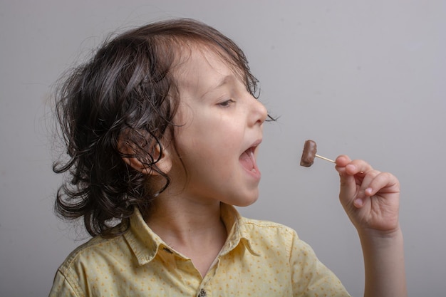 Portrait d'un garçon mignon mangeant du chocolat