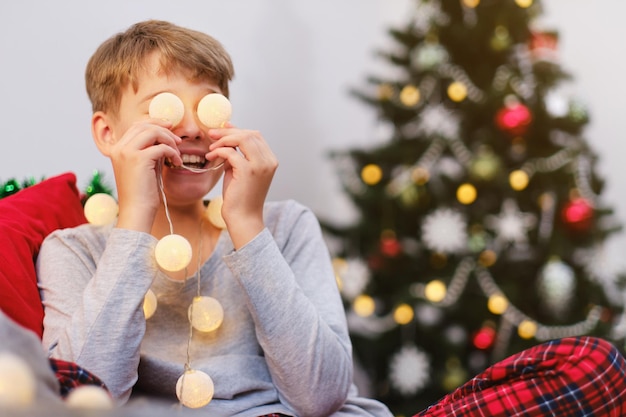 Portrait d'un garçon de Noël avec des boules de Noël sur les yeux