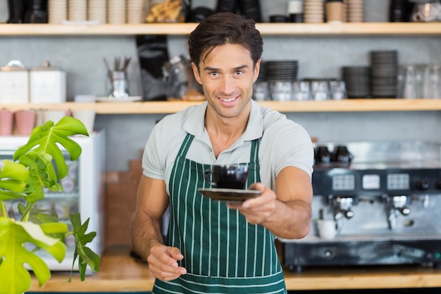 Portrait de garçon offrant une tasse de café