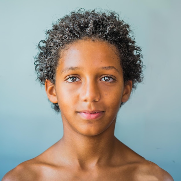 Portrait d'un garçon sans chemise sur un fond bleu
