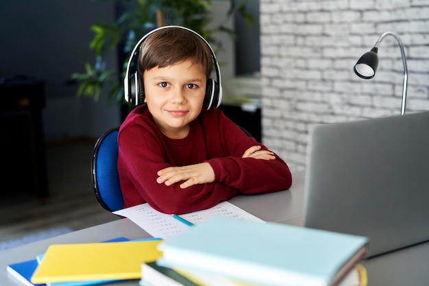 Portrait d'un garçon souriant pendant qu'il étudie à la maison